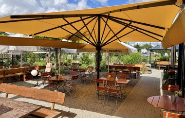 Biergarten mit Biertischen und Schirmen | © Touristikgemeinschaft Hohenlohe e. V. | Wohnmobilstellplatz HEICamp