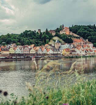 Ein Fluß (Neckar). Au fder anderen Uferseite ist eine Stadt zu sehen. Auf einem Berg ein Schloss. Hirschhorn im Odenwald. | © Touristikgemeinschaft Odenwald e.V.