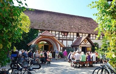 Menschen sitzen im Sommer vor dem Weingut Birkert | © Touristikgemeinschaft Hohenlohe e. V.