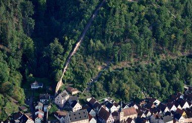 Luftbildaufnahme auf Teile der Altstadt Freudenberg am Main, die Burgmauer und die von Wald umgebene Burganlage. | © Liebliches Taubertal