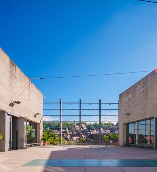 Außenansicht der Kunsthalle Würth mit blauem Himmel und Sonnenschein.