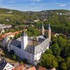 Luftaufnahme vom Residenzschloss Mergentheim. Man sieht den Schlosshof mit den Kirchtürmen, der Schlosspark im Hintergrund | © Björn Hänssler