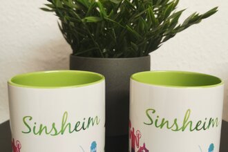 Zwei Tassen mit Sinsheim-Skyline und grünem Schriftzug | © Tourist-Info Sinsheim