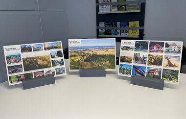 Drei verschiedene bunte Postkarten mit Sinsheimer Fotos in Halterung | © Tourist- Info Sinsheim