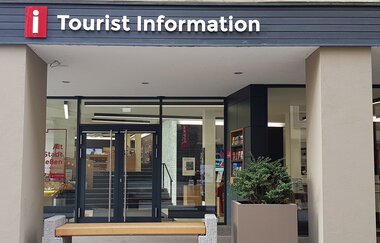 Eingang zur Tourist Information in Schwäbisch Hall mit Glasfront und Informationsmaterialien. | © Leoni Friedrich