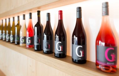 Verschiedene Weinflaschen des Weingut Gmelin auf einem Holzregal